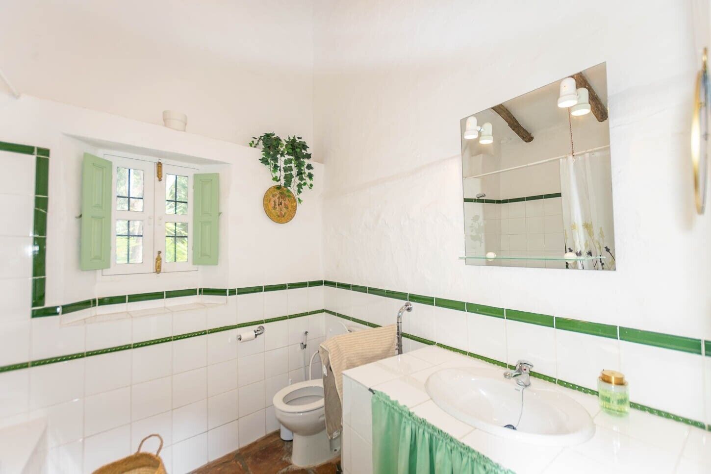 Un baño con inodoro, lavabo y espejo.