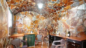 A stone-walled room with a wine rack, chairs, and a wine cooler. - Eveas – Private Villa with Pool in Tenerife (Candelaria)