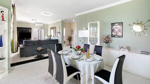 A dining area with a round table set for four, surrounded by chairs. - Eveas – Private Villa with Pool in Tenerife (Candelaria)