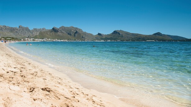 A beach with clear water, sandy shore, and mountains in the background. - Villa 'Ginebro Puerto Pollença' with Private Pool, Wi-Fi and Air Conditioning (Puerto Pollença)