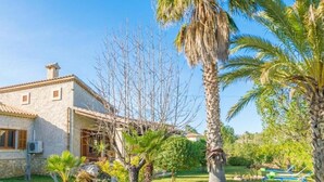 A stone house with a garden, palm trees, and a clear sky. - Villa 'Ginebro Puerto Pollença' with Private Pool, Wi-Fi and Air Conditioning (Puerto Pollença)