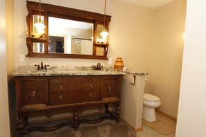 A bathroom with a wooden vanity, a large mirror, a marble countertop, and a toilet. - Alegria!  Five Bedroom Colonial Style Home Conveniently Located! Pet Friendly! (Moses Lake)