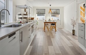 A modern kitchen with a large island, stainless steel appliances, and a view of a snowy landscape through the windows. - Stunning home in Sydals with WiFi (Sydals)