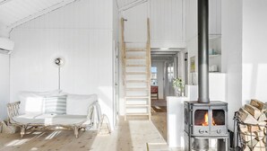 Una habitación acogedora con una cama, una escalera de madera, una chimenea y vistas al exterior.