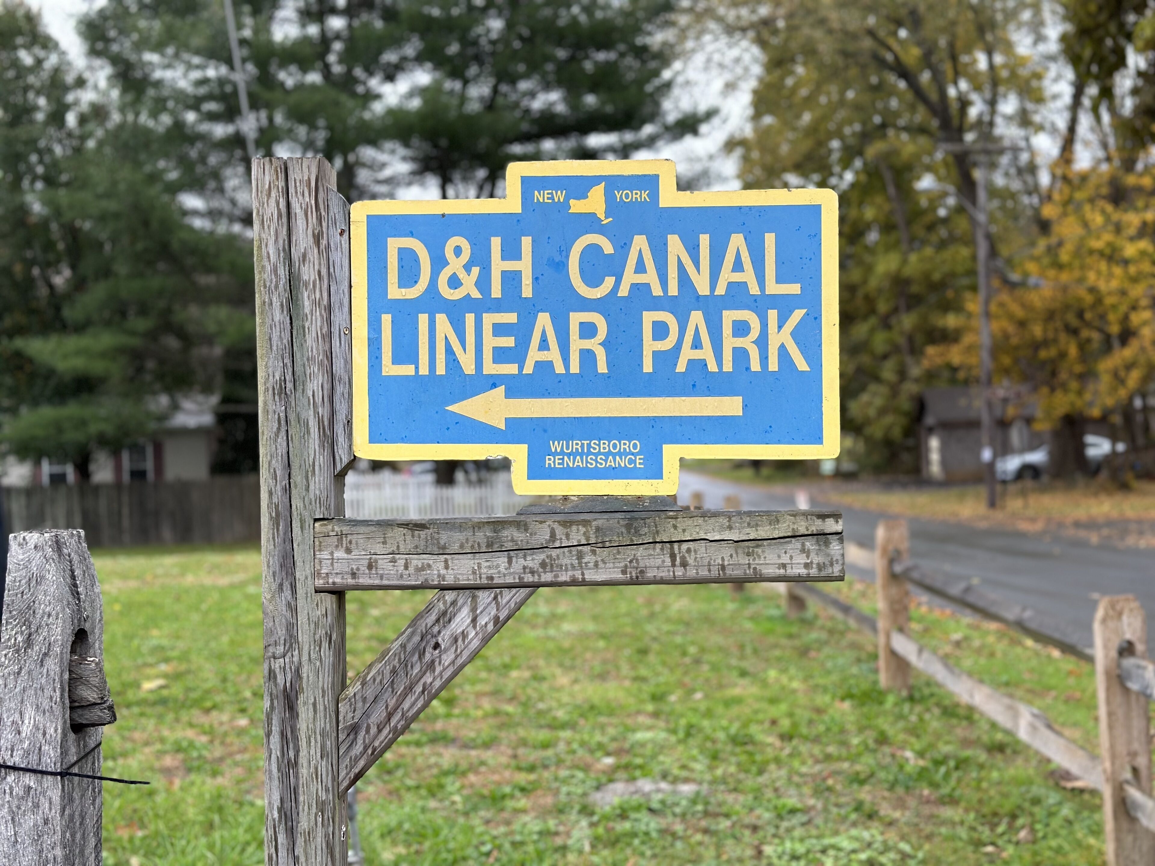 A directional sign for D&H Canal Linear Park pointing left.