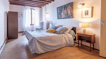 Une chambre à coucher avec un lit, une table de chevet, une lampe et un tableau au mur.
