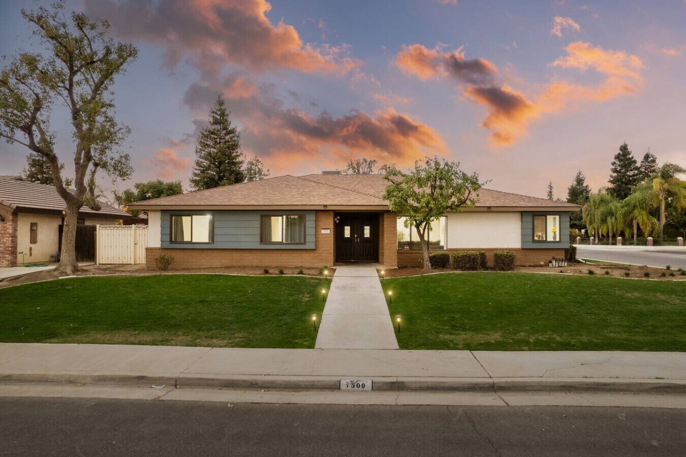 A two-story house with a front yard, a driveway, and a street view.