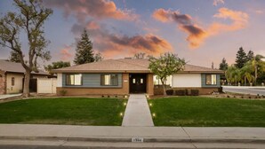 A two-story house with a front yard, a driveway, and a street view. - Urban Escape! Massive home in Central Bakersfield! (Bakersfield)