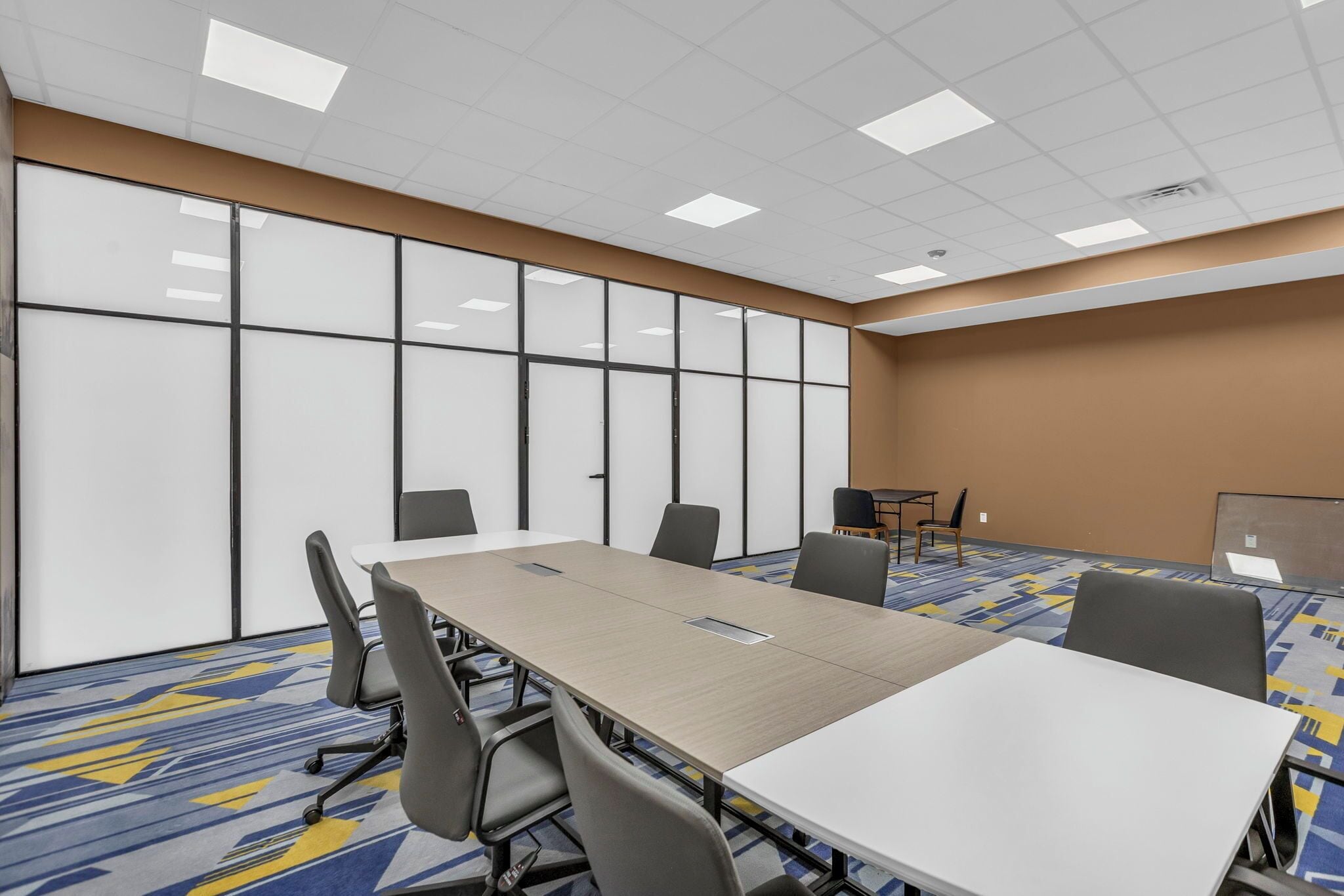 A conference room with a long table, chairs, and a whiteboard.