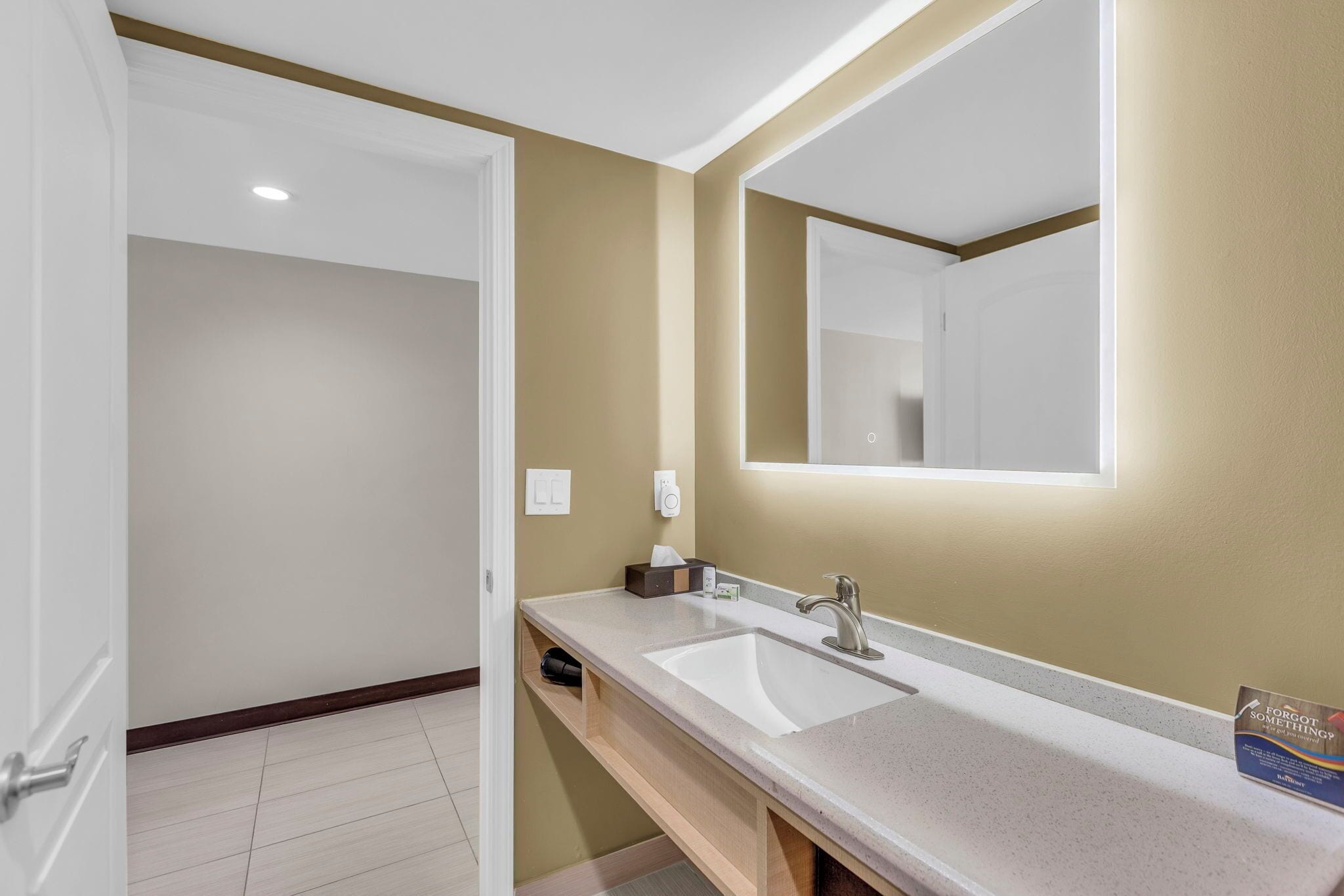 A bathroom with a white sink, a mirror, and a towel rack.