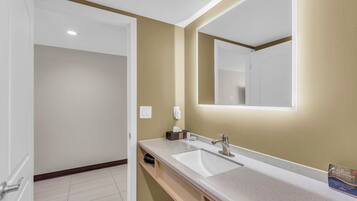 A bathroom with a white sink, a mirror, and a towel rack.