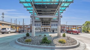 A modern building with a glass entrance and a landscaped area with small plants and rocks. - Baymont by Wyndham Kansas City North (North Kansas City)