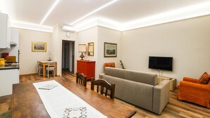 A modern living room with a sofa, a dining table, and a TV. - Awesome apartment in Camaiore with WiFi (Camaiore)