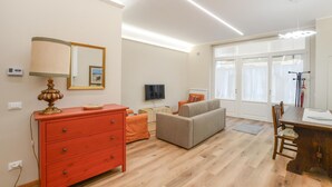 A modern living room with a red dresser, a grey sofa, and a television. - Awesome apartment in Camaiore with WiFi (Camaiore)