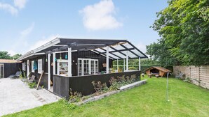 A modern house with a covered patio, a small garden, and a wooden playhouse. - 3 bedroom amazing home in Vejby (Vejby)