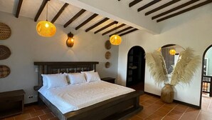 A bedroom with a wooden bed, a large window, and a view of the outside. - Hotel Ecoluxe (El Peñol)