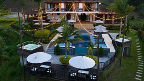 A resort with a swimming pool, outdoor seating, and string lights. - Hotel Ecoluxe (El Peñol)
