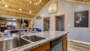 A kitchen with granite countertops, stainless steel sinks, and wooden cabinets.