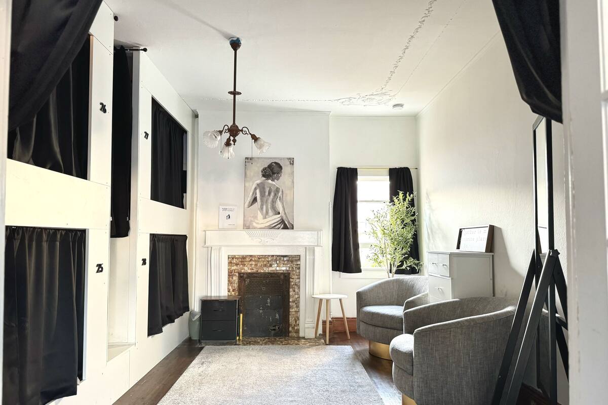 Um quarto com lareira, um candelabro e um quadro na parede.