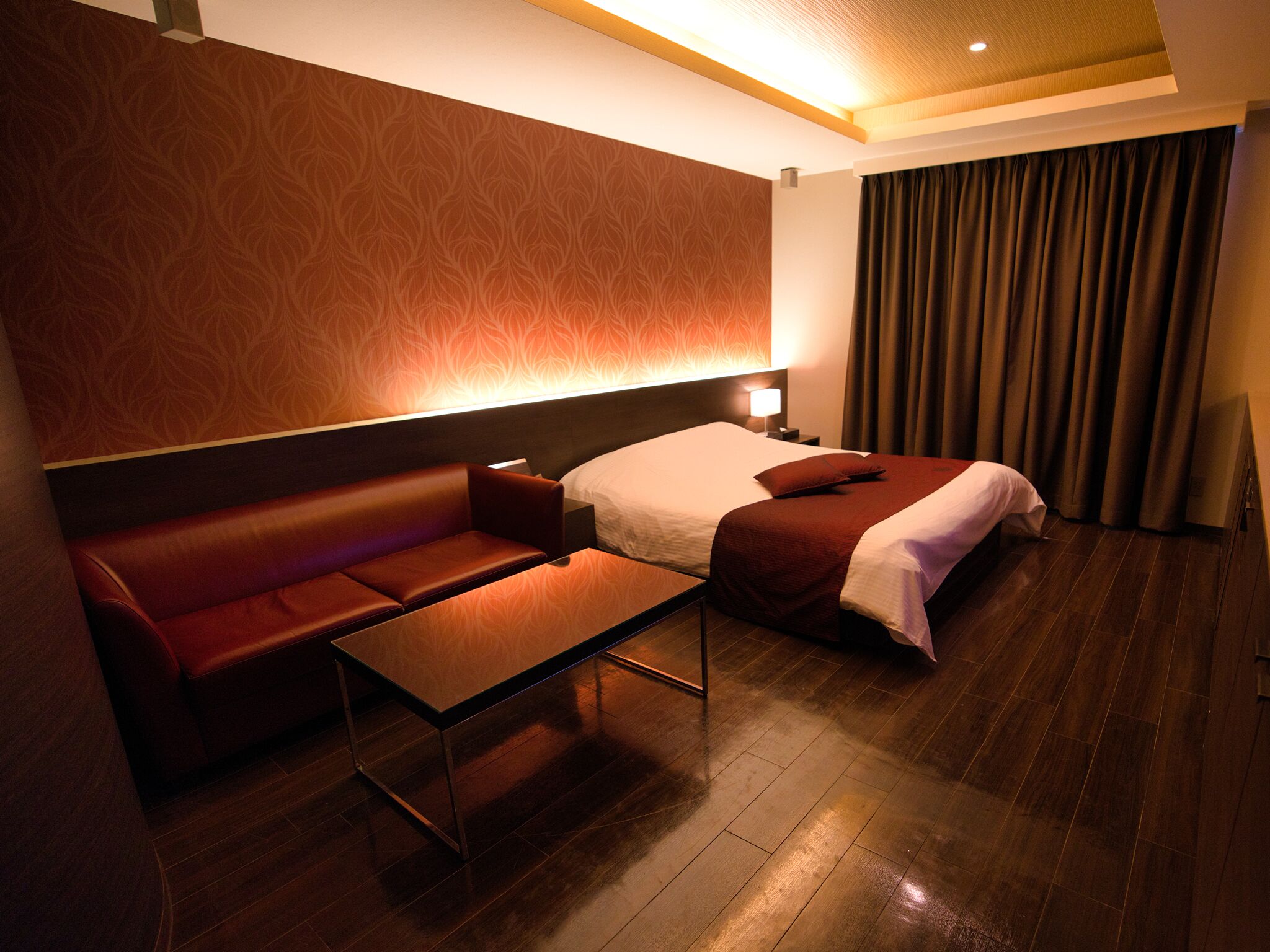 Ein Hotelzimmer mit Bett, Sofa, kleinem Tisch und Nachttisch.