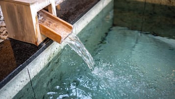 Una fuente de agua con una estructura de madera y un arroyo cristalino.