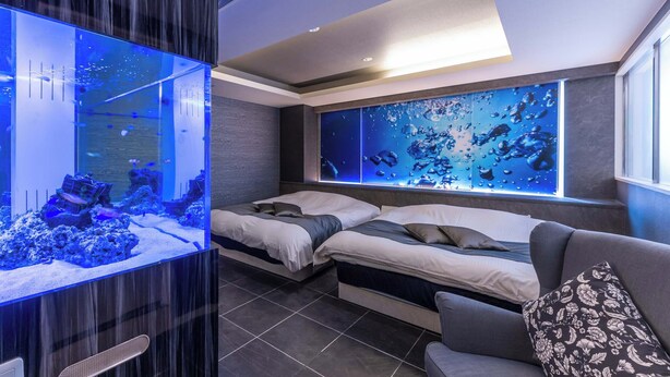 A modern bedroom with two beds, a large aquarium, and a wall mural. - HOTEL felice Osaka Itami airport (Toyonaka)
