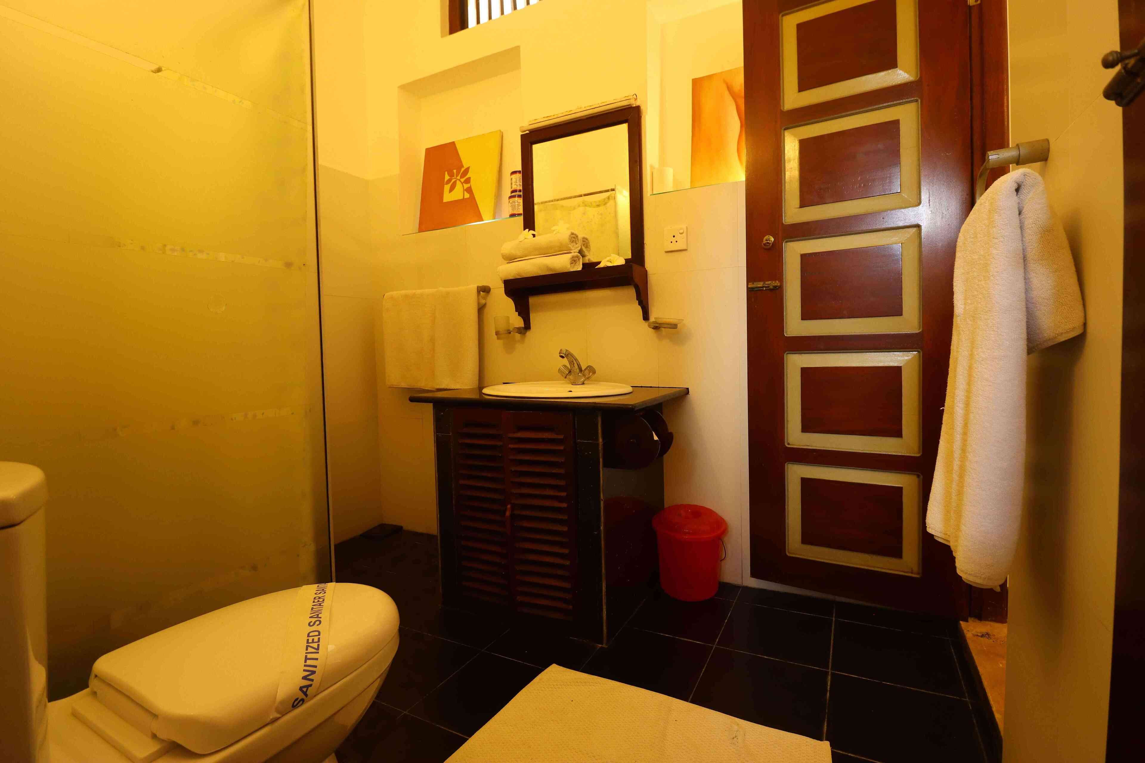 A compact bathroom with a toilet, sink, and mirror.