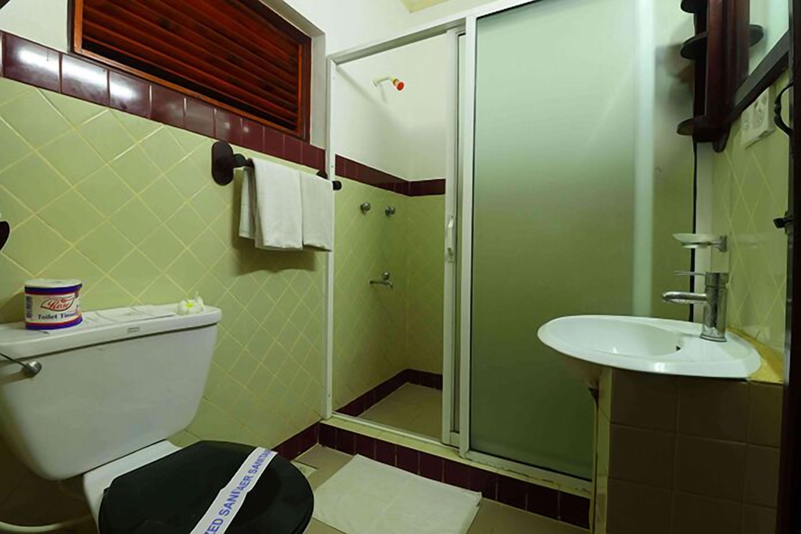 A bathroom with a toilet, a shower, and a sink.