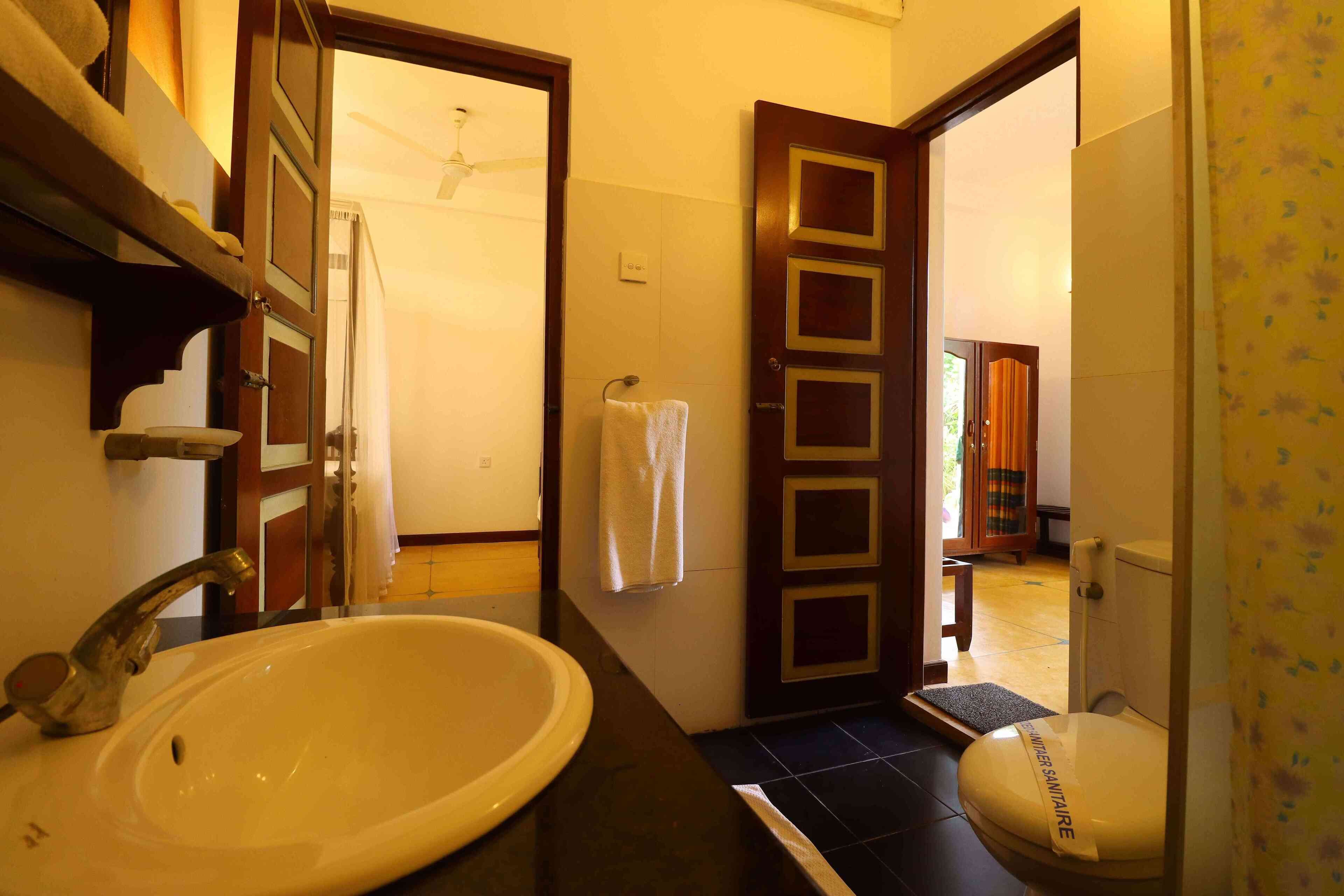 A bathroom with a sink, toilet, and towel rack.
