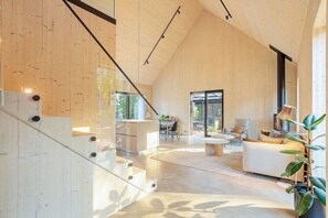 A modern interior with a staircase, a dining area, and a seating space. - Villa Pickala - Design - Seafront - Hot tub (Siuntio)