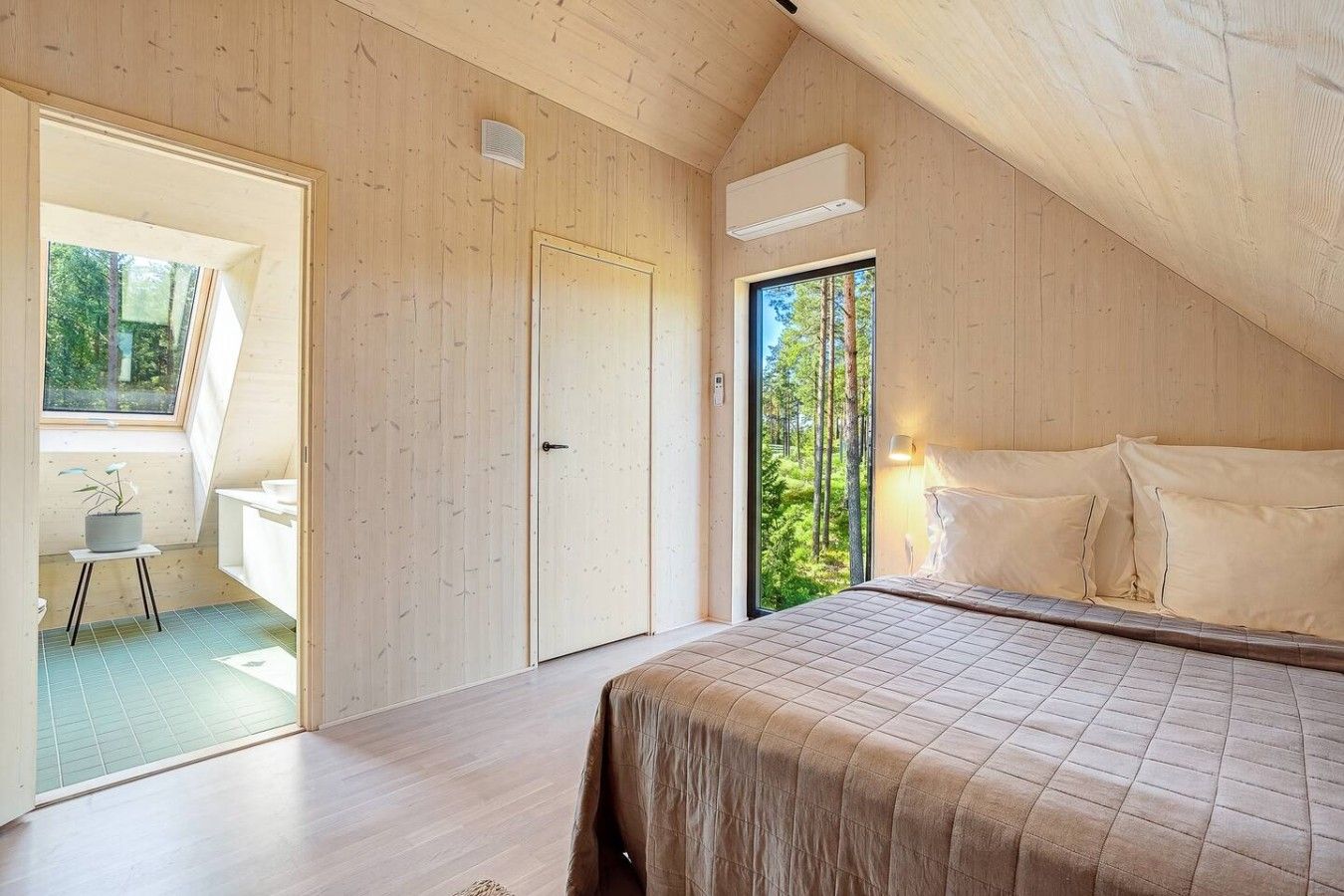 A bedroom with a bed, a window, and a door.