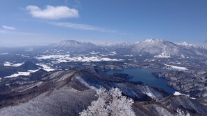 Vista panorámica de un paisaje montañoso con un lago y picos nevados.