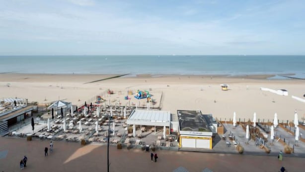 A beachside area with a large open space, a covered seating area, and a small building with a sign. - Escape with sea view by Interhome (Blankenberge)
