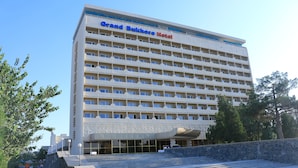 A multi-story hotel with a prominent sign reading "Grand Bukhoro Hotel." - Grand Bukhara (Bukhara)
