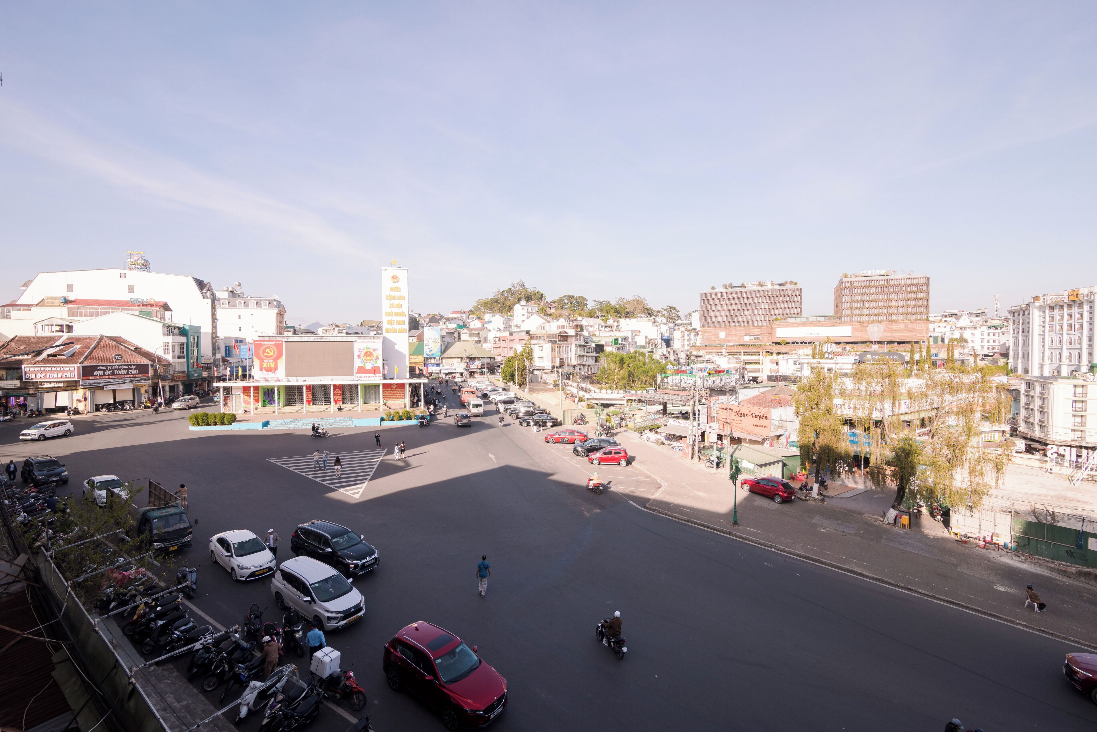 Ein Stadtbild mit einer breiten Straße, Gebäuden und geparkten Autos.