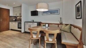 A modern apartment with a dining area, kitchen, and living space.