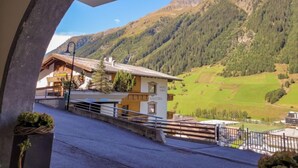 Vista de la montaña desde la entrada de un hotel con fachada de madera y un letrero que dice 'Motel Carina'.