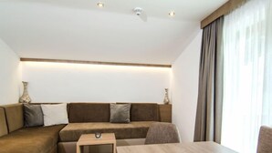 Una sala de estar moderna con un sofá modular, una mesa de centro de madera y una mesita auxiliar.