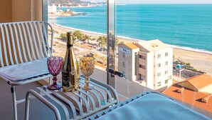 A balcony with a view of the beach and ocean, a bottle, and two glasses on a table. - Hound Hotel Ulsan (Ulsan)