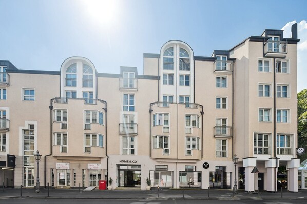 A multi-story building with a modern architectural style, featuring a central arched window and multiple balconies. - Home and Coliving Bonn Aparthotel (Bonn)