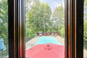 A swimming pool with a red umbrella, surrounded by a wooden deck and a fence. - Quiet, upscale Boston Suburb stay-fast access to Boston hub & hospitals STR25-22 (Newton)