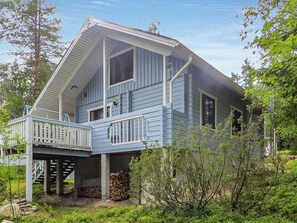 A two-story house with a balcony and a covered porch area. - Ukkorinne mökki by Interhome (Hyrynsalmi)