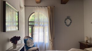 Una camera da letto con un letto, una sedia, una scrivania e una finestra.