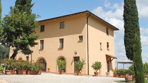 Un edificio a due piani con tetto piatto e facciata simmetrica, caratterizzato da numerose finestre e un ingresso centrale.