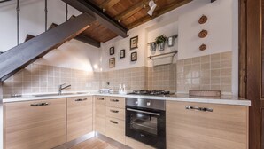 Een moderne keuken met houten kastjes, een roestvrijstalen fornuis en een betegelde achterwand.
