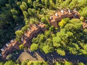 Luchtbeeld van een woonwijk met meerdere huizen, elk met een schuin dak en zonnepanelen.