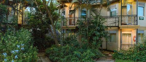 A two-story building with balconies and a garden area.