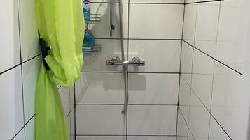 A small bathroom with a shower, a sink, and a toilet.