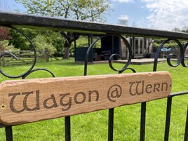 Un letrero de madera con el texto "Wagon @ Wiern" sujeto a una cerca de metal.