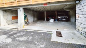 A parking garage with two cars parked inside. - Charming 19m² Studio for 3 with Terrace and Parking, 5min from Shops & Free Shuttle (Arêches-Beaufort)